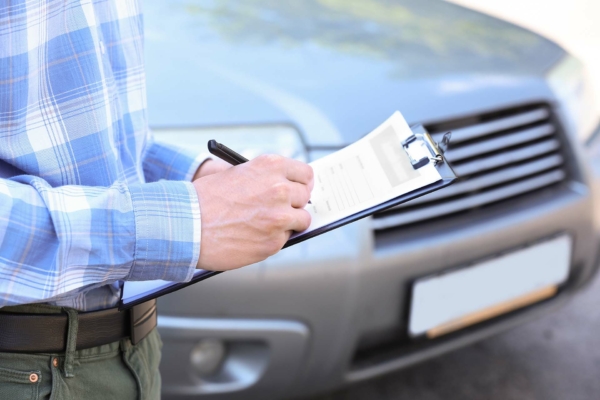 Insurance agent near car on road